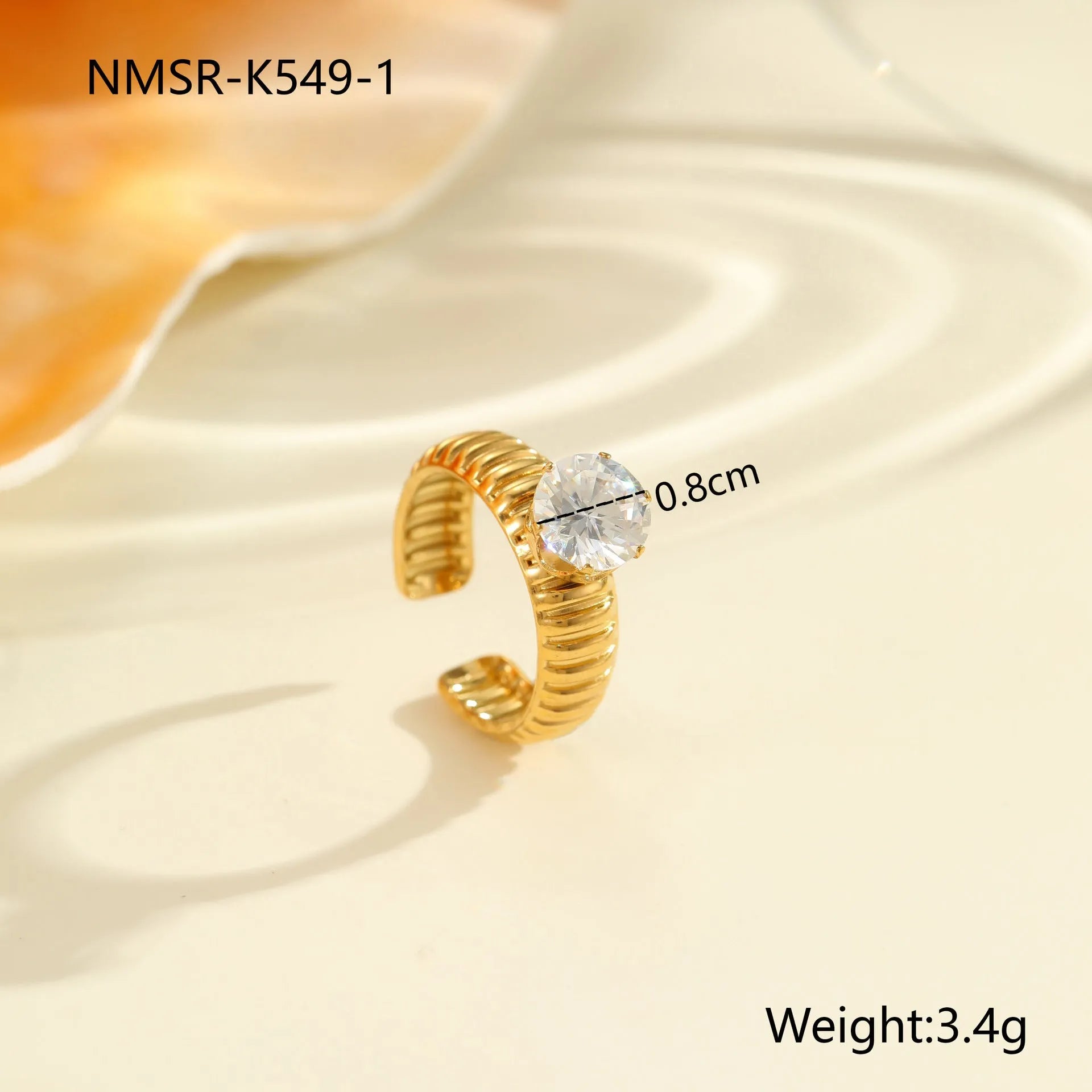 Gold inlaid zircon geometric heart and drop shape stainless steel ring on white background.