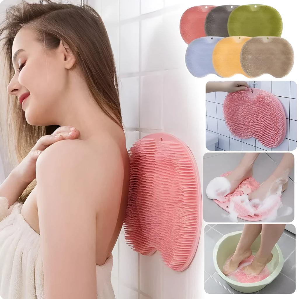 Orange suction cup bath brush with silicone bristles for foot and back cleaning on a bathroom floor.