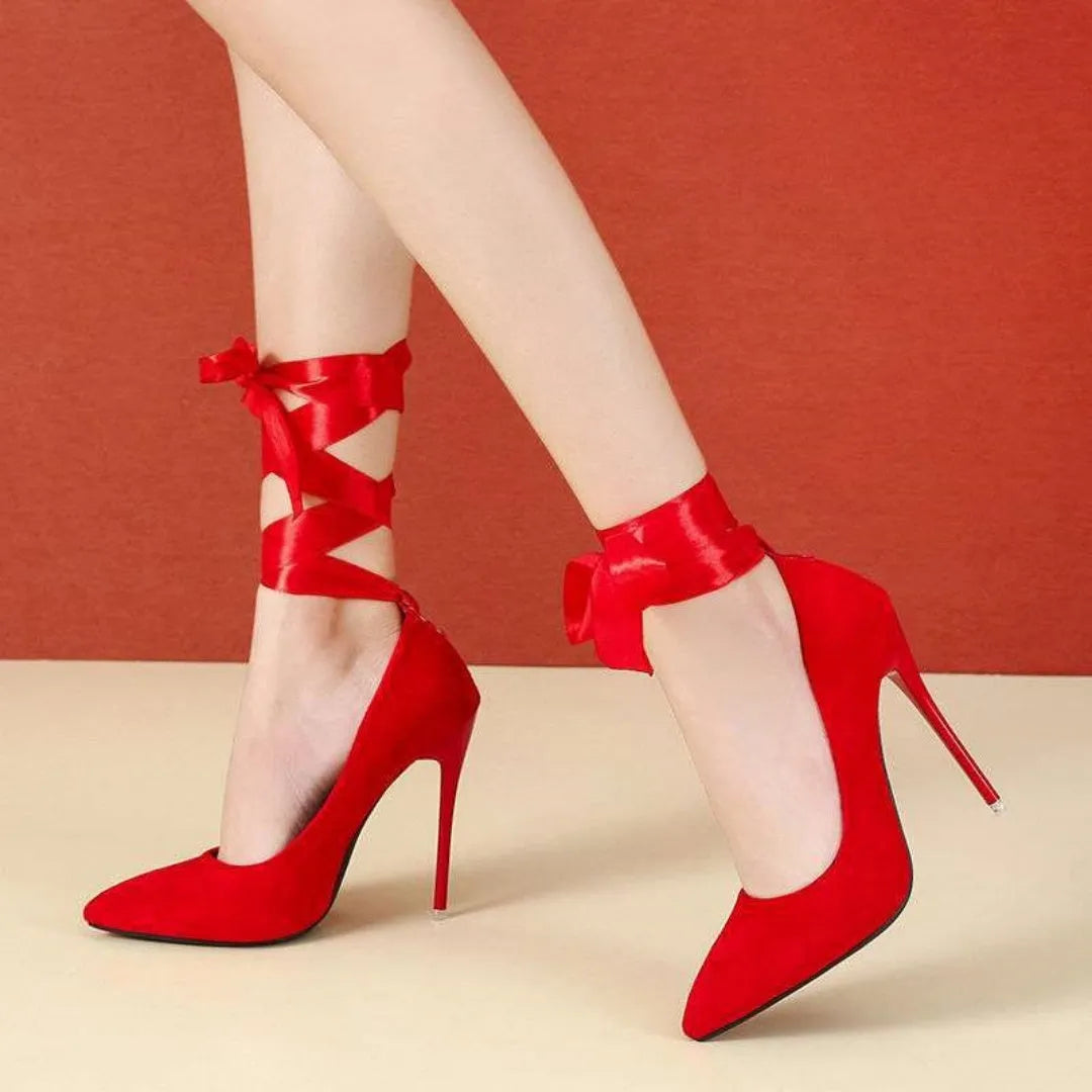 Black pointed toe high heel pump with a lace strap across the foot on a 12cm heel.