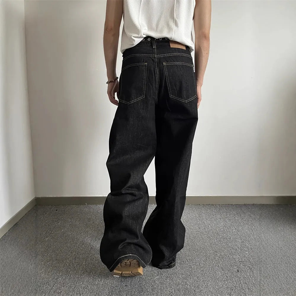 A pair of black loose wide-leg jeans with a straight-leg cut and zip fly on a mannequin.