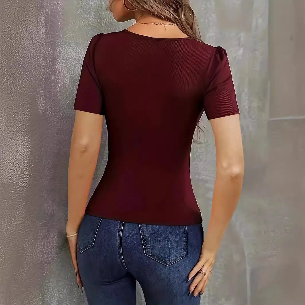 Woman wearing a wine red slim fit knitted short sleeve pullover top with a low neckline.
