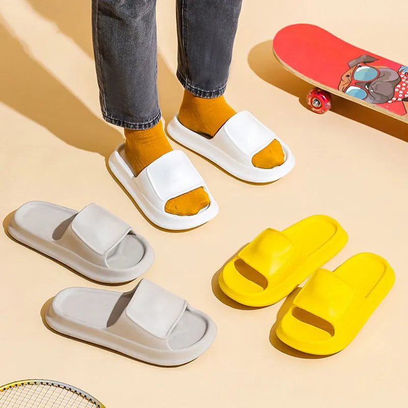 Pair of thick-soled white EVA foam flip-flop slippers on a bathroom floor, showing non-slip tread pattern.