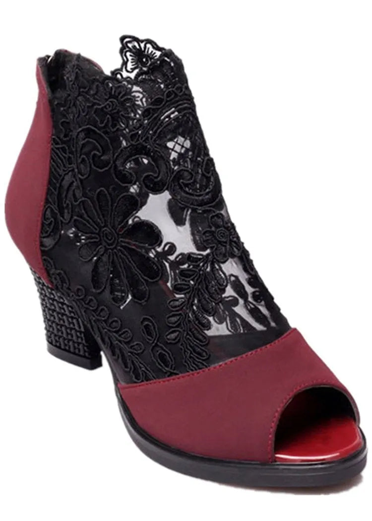 Black women's gladiator sandals with floral lace upper, high square heel, and a front zip closure.