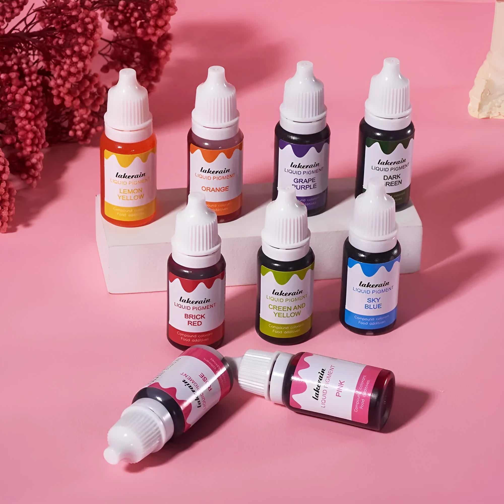 Set of 24 small bottles of craft pigment in various colours next to toy toolbox, boots, gloves, and other accessories.