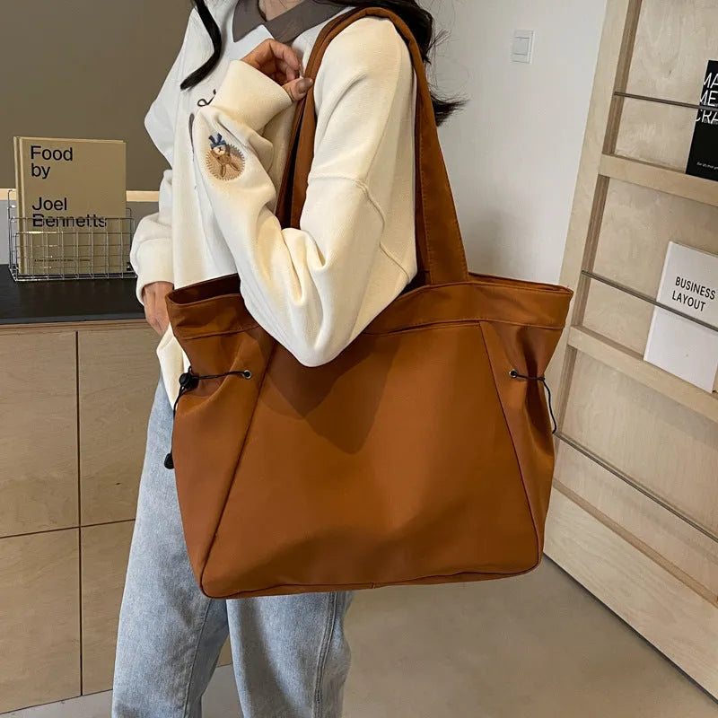 Soft Oxford cloth commuter tote bag in a street style, shown in a folded position.