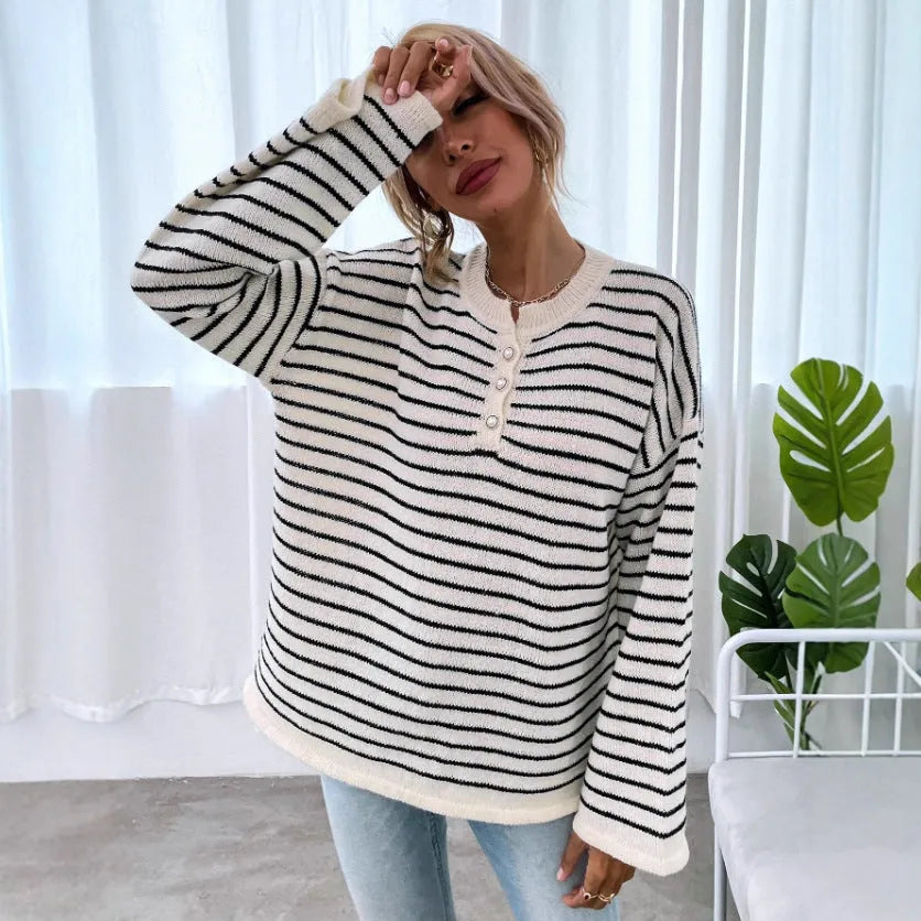 Black striped women's loose long-sleeve top with drop shoulders on a hanger.