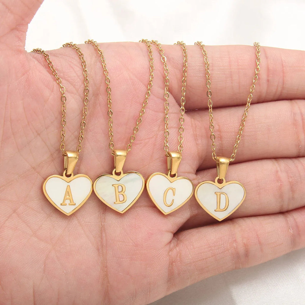Gold plated heart pendant necklace with white shell centre on a stainless steel chain.