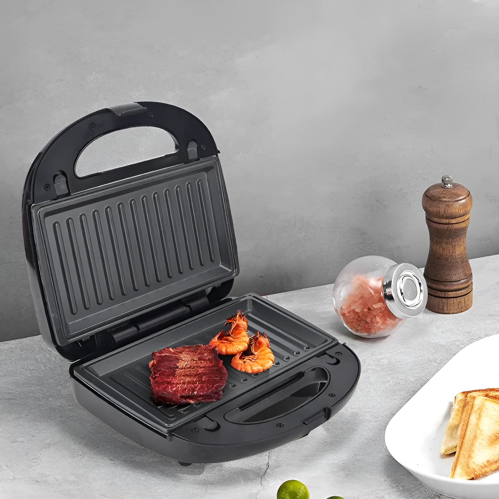 Black electric sandwich pan with double-sided heating and brushed stainless steel cover
