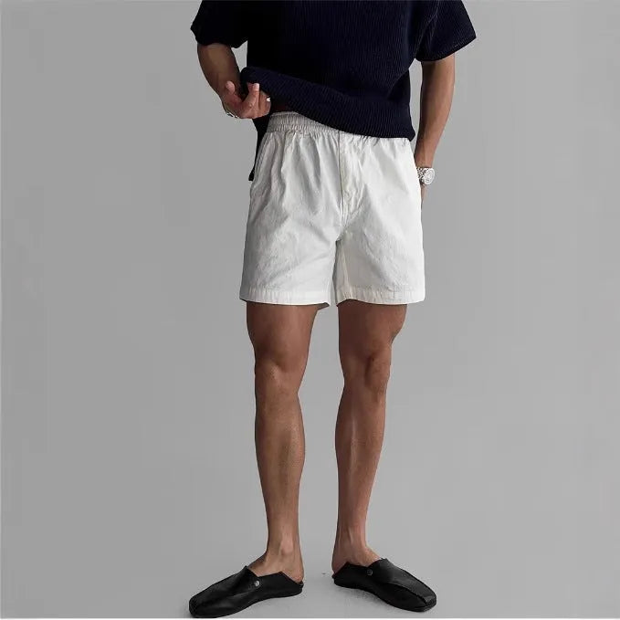Man's loose-fit cotton sports shorts in khaki colour on a white background.
