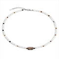 Men's vintage white shell necklace with round bead chain on neutral background