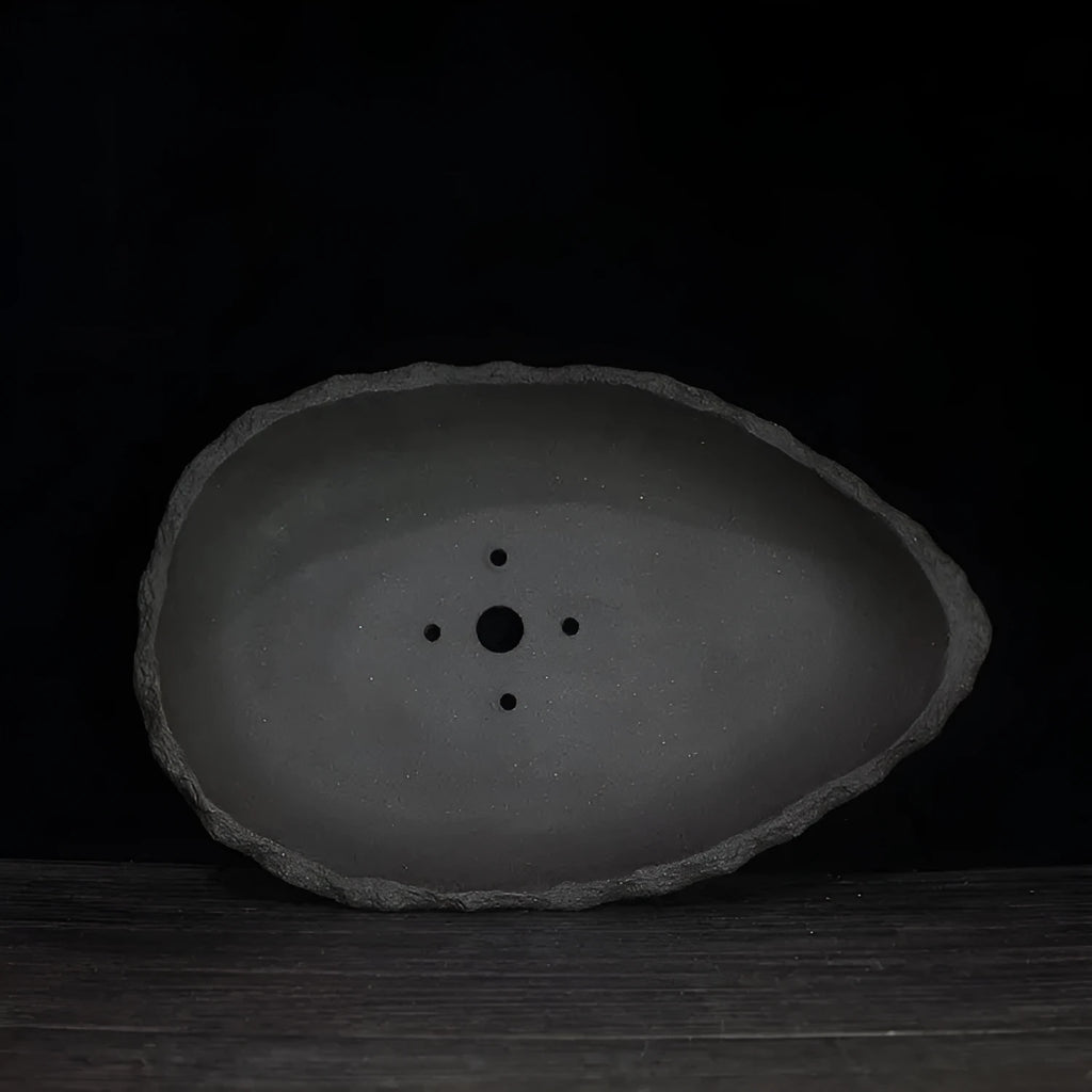 Handmade purple clay flower pot showing unique shape and traditional ceramic texture