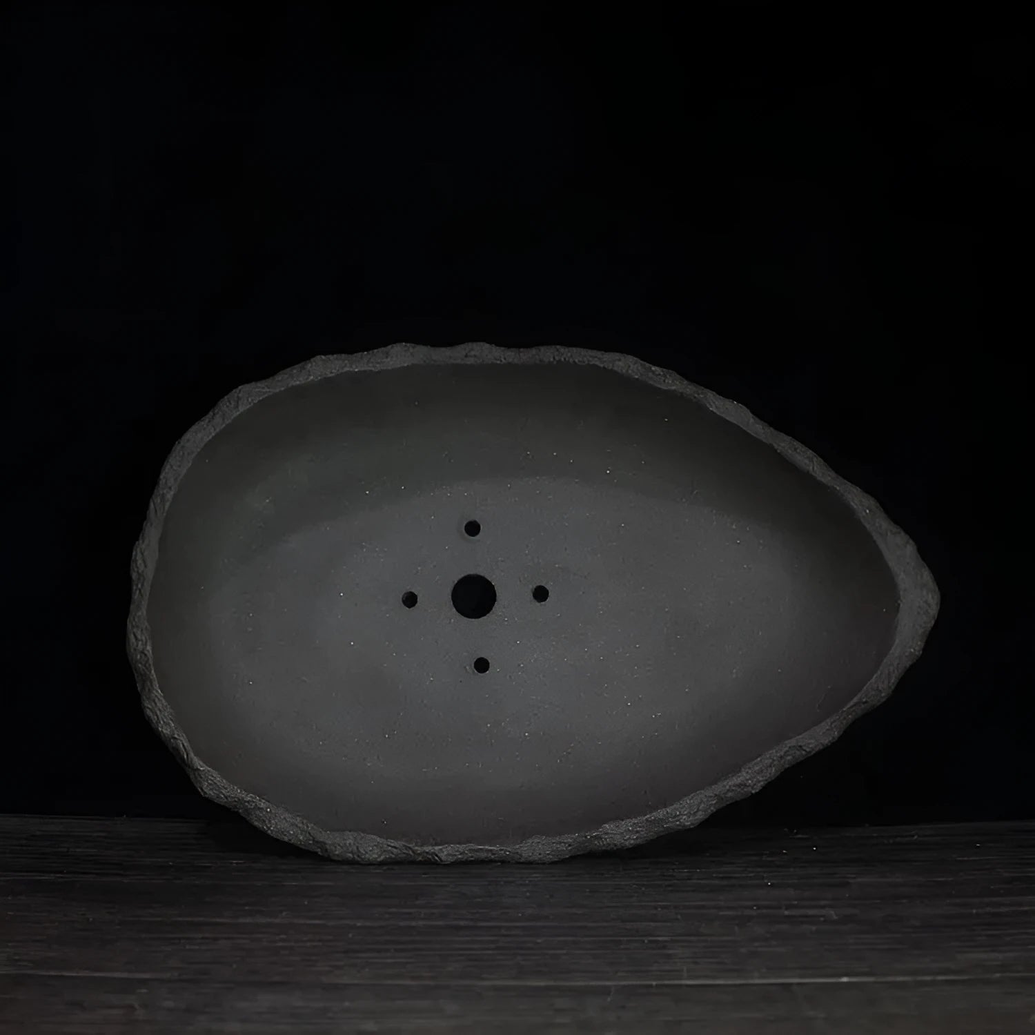 Handmade purple clay flower pot showing unique shape and traditional ceramic texture