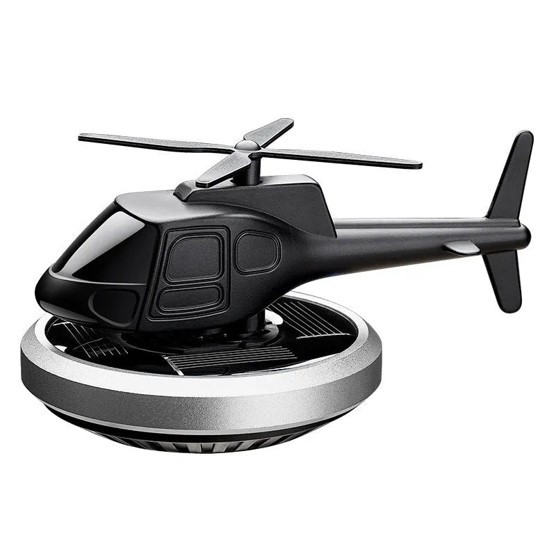 Silver metal solar-powered rotating helicopter car perfume ornament on dashboard