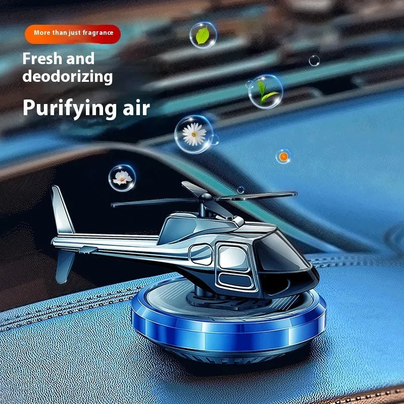Silver metal solar-powered rotating helicopter car perfume ornament on dashboard