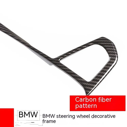 Black carbon fibre pattern button frame decoration for a BMW steering wheel.