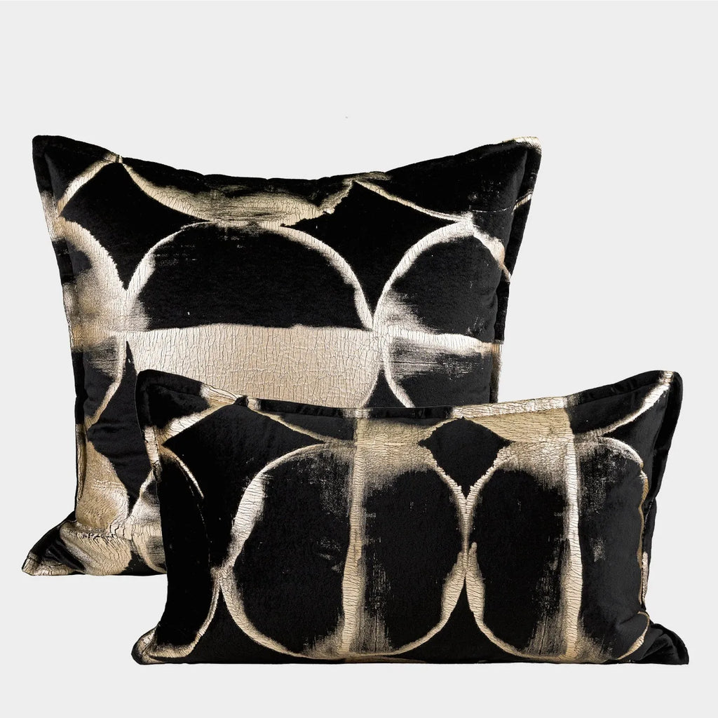 Black and gold abstract patterned flannel cushion on a sofa, showing removable cover.