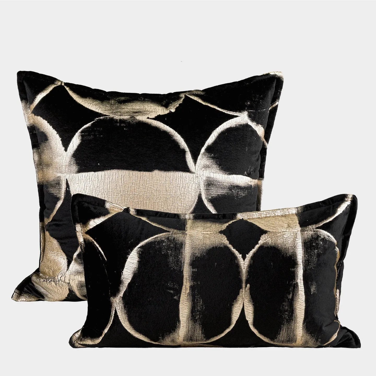 Black and gold abstract patterned flannel cushion on a sofa, showing removable cover.