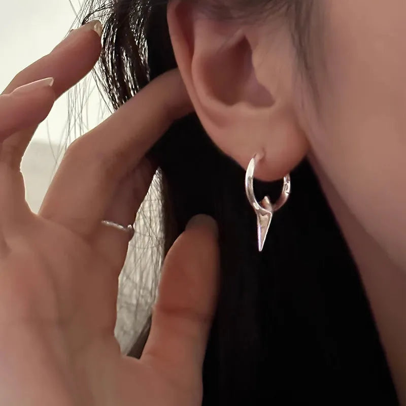 A pair of platinum-coloured geometric star-shaped ear clips for women on a white background.