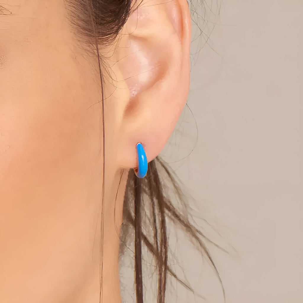 Geometric U-shaped silver wire drop earrings with glossy oval epoxy resin elements in various colours.