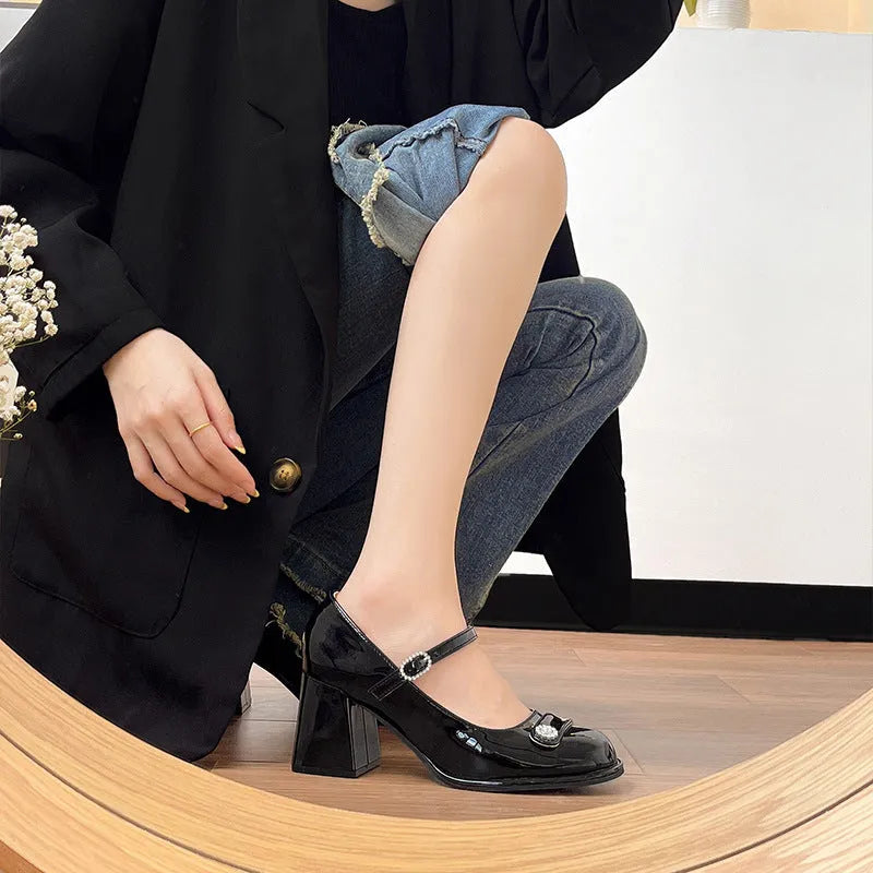 Women's black patent leather wide-fit chunky heel shoes with round toe and buckle fastening.