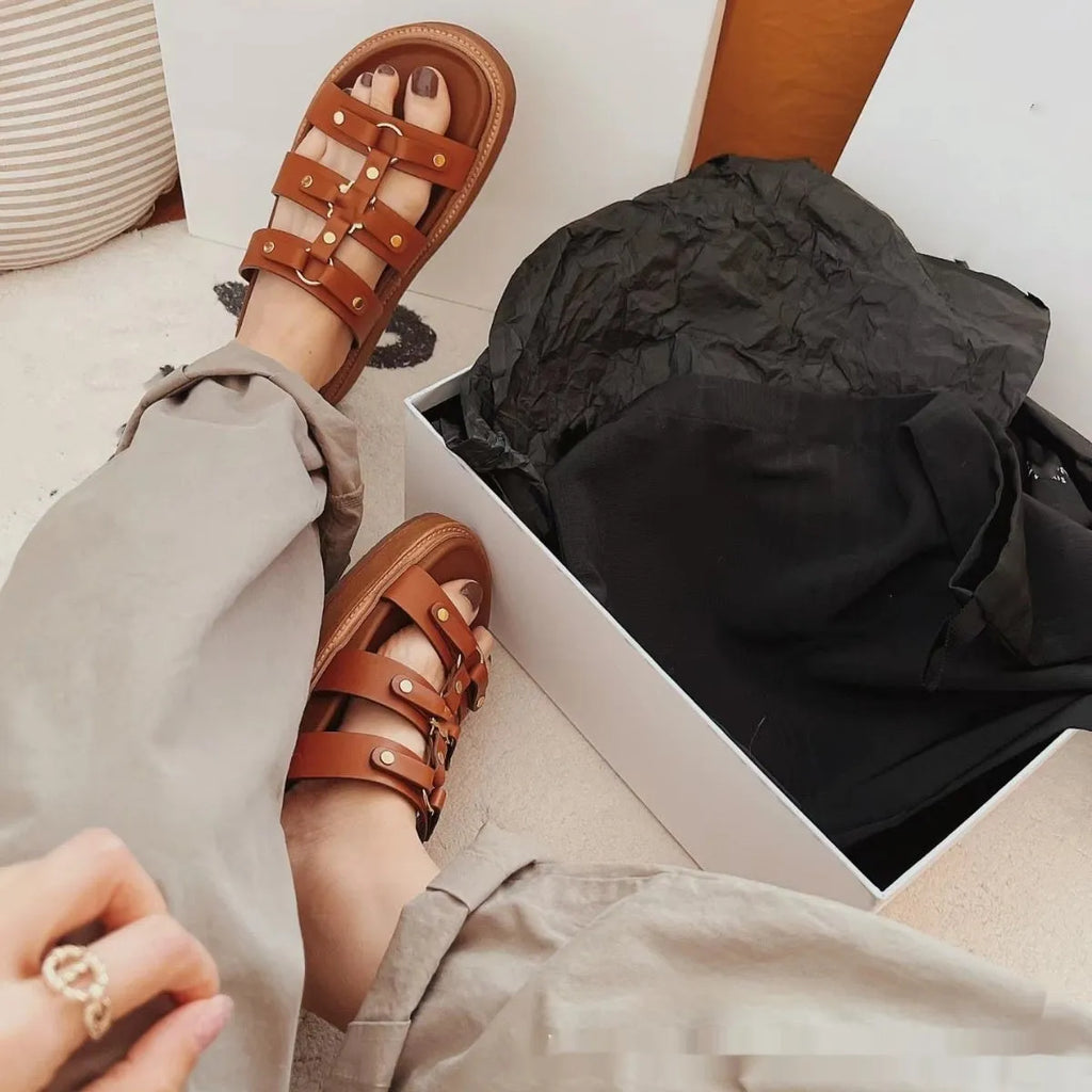 Women's white patent leather Roman sandal slippers with sheepskin lining shown from the side.