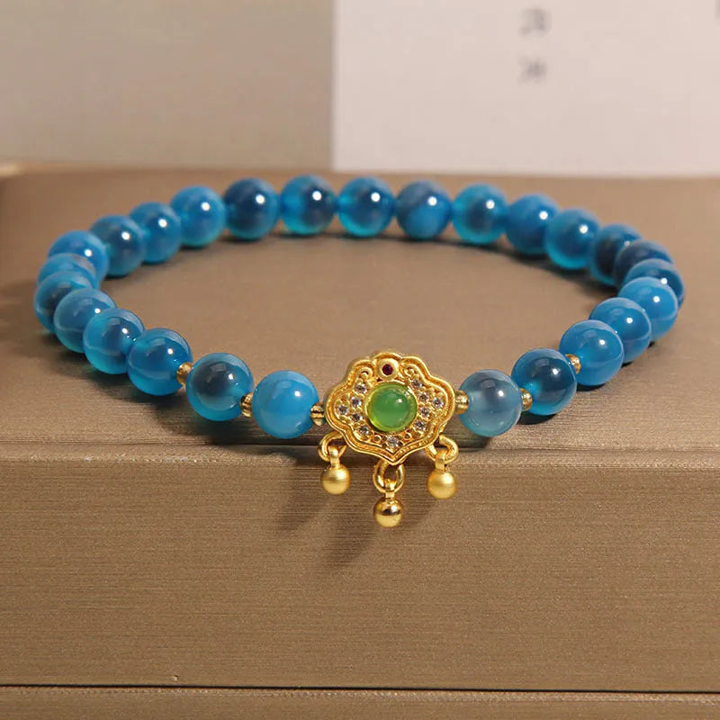 Blue sugar heart agate safety lock pendant on a crystal women's bracelet with rhinestone details.
