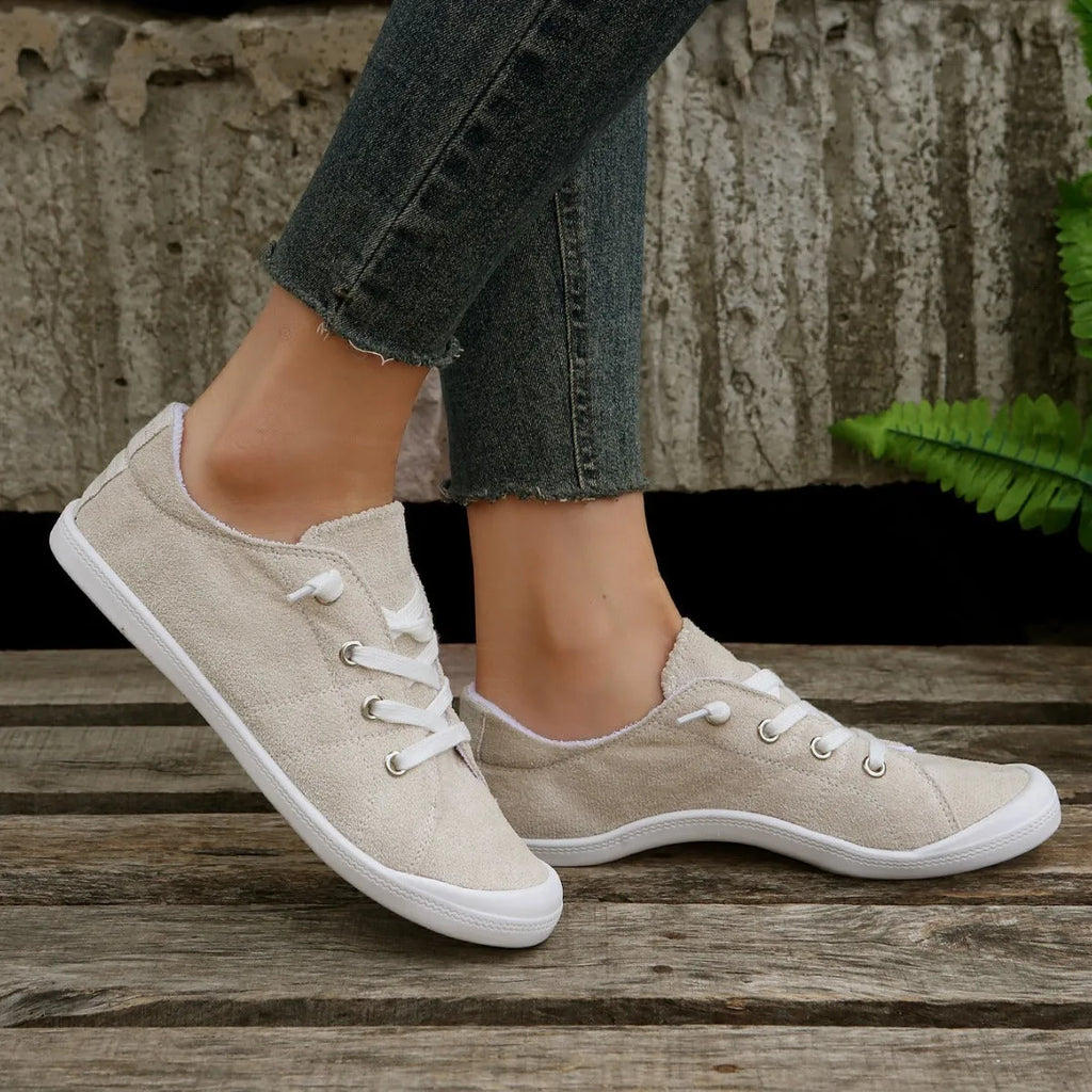 Women's creamy-white fabric casual sneakers with rubber soles shown in low-top design