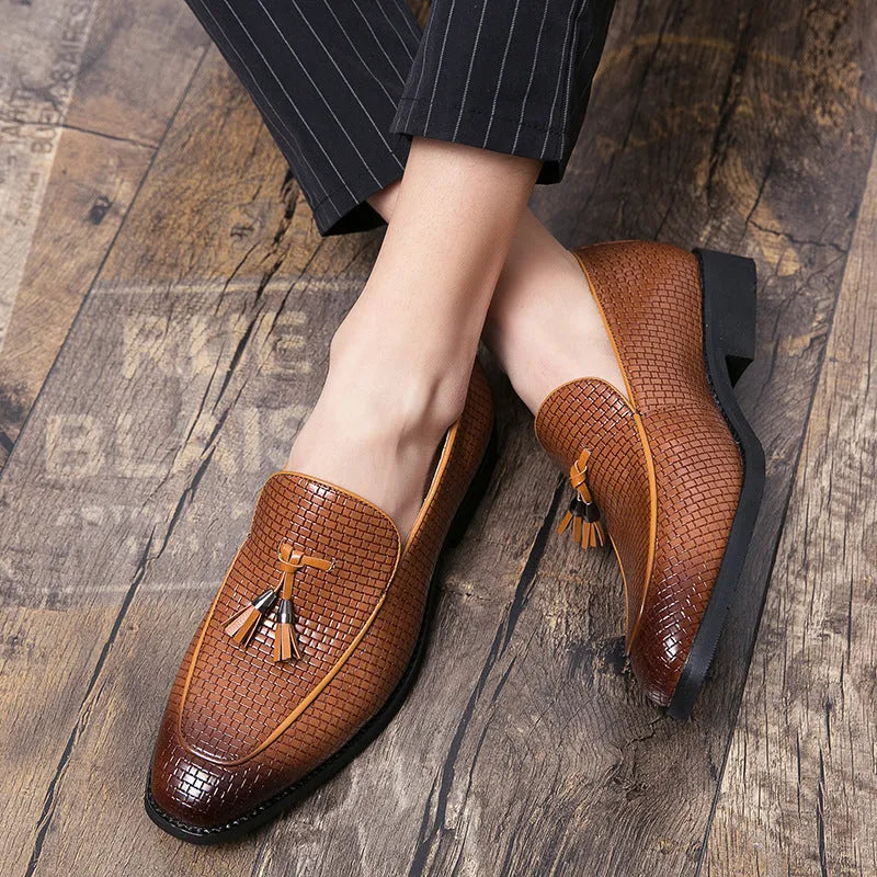 Men's black pointed toe slip on shoes with a gold tassel detail on the upper.