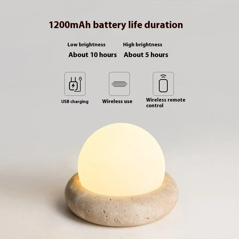 Cream-coloured modern bedside night lamp with remote control on wooden table
