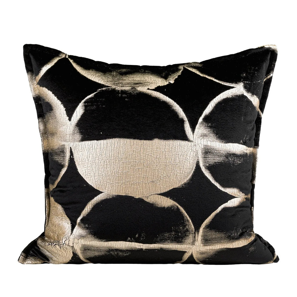 Black and gold abstract patterned flannel cushion on a sofa, showing removable cover.