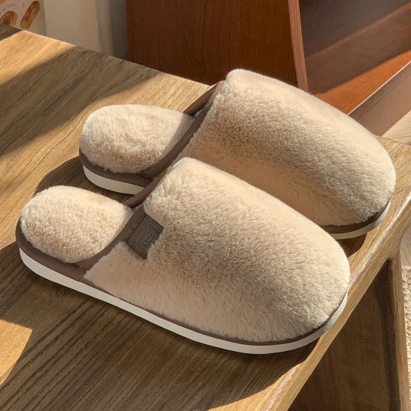 A pair of solid colour plush winter slippers with a non-slip PVC sole and car stitching detail.