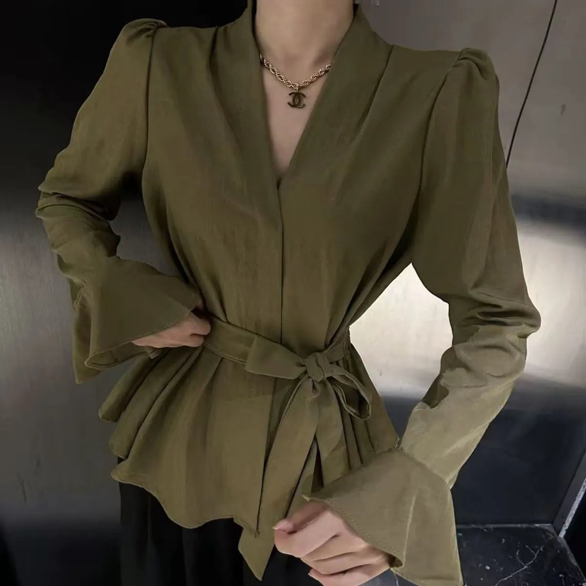 Women's black French-style tied shirt with an irregular collar and long bell sleeves.