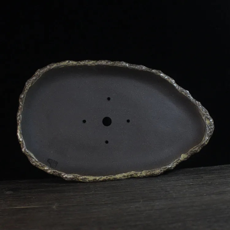 Handmade purple clay flower pot showing unique shape and traditional ceramic texture