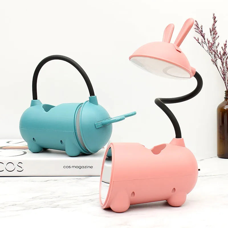 Green cartoon-themed USB table lamp with pen container base on desk
