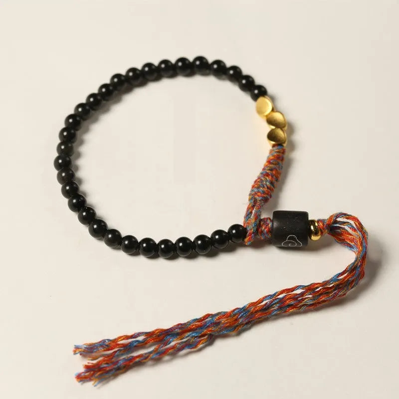 Hand-woven obsidian carrying strap bracelet showing woven texture and 4mm width
