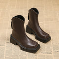 Black and brown platform Martin boots with square toe, high heel, and back zipper closure.
