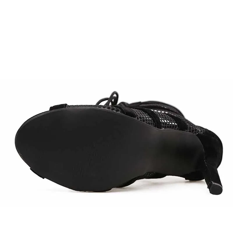 Black suede women's lace-up high heel shoes with a high stiletto heel on a plain background