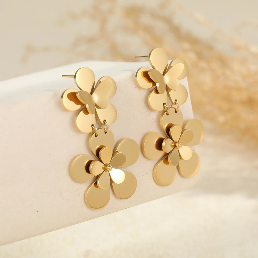 Women's stainless steel earrings with 18K gold electroplated finish featuring floral butterfly and geometric zodiac design