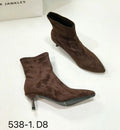 Black pointed toe stiletto ankle boots with a mid-calf sock length on a model.