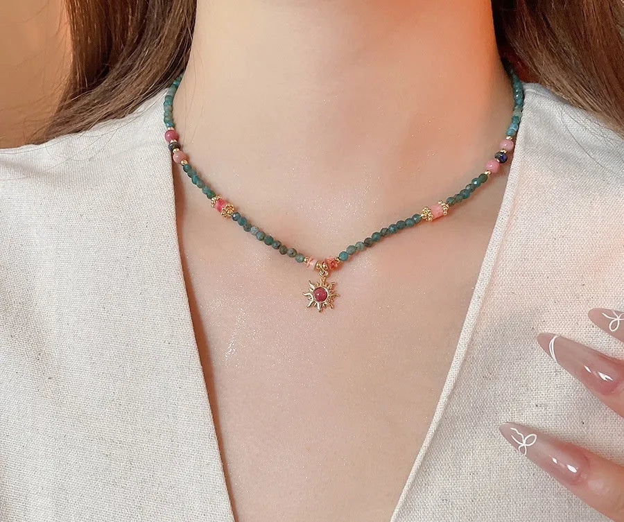 Sun necklace with a stone geometric pendant and freshwater pearls on a clavicle chain.