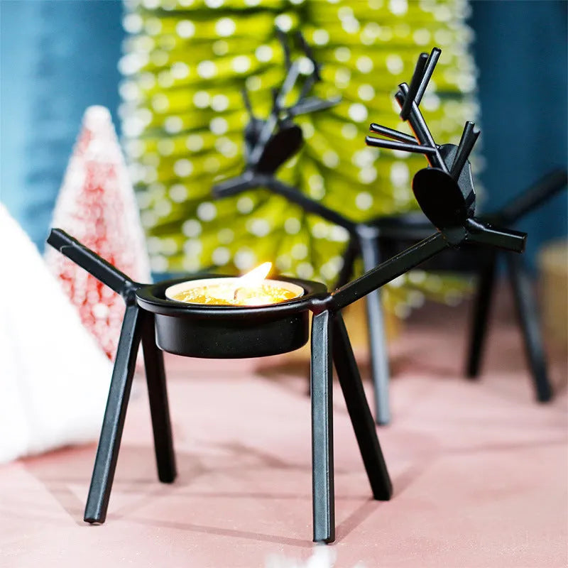 Black iron Christmas candlestick holder with decorative elk antler design.