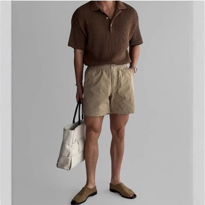 Man's loose-fit cotton sports shorts in khaki colour on a white background.