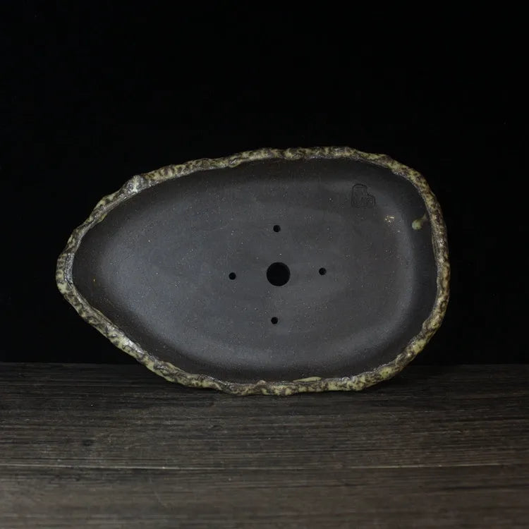 Handmade purple clay flower pot showing unique shape and traditional ceramic texture