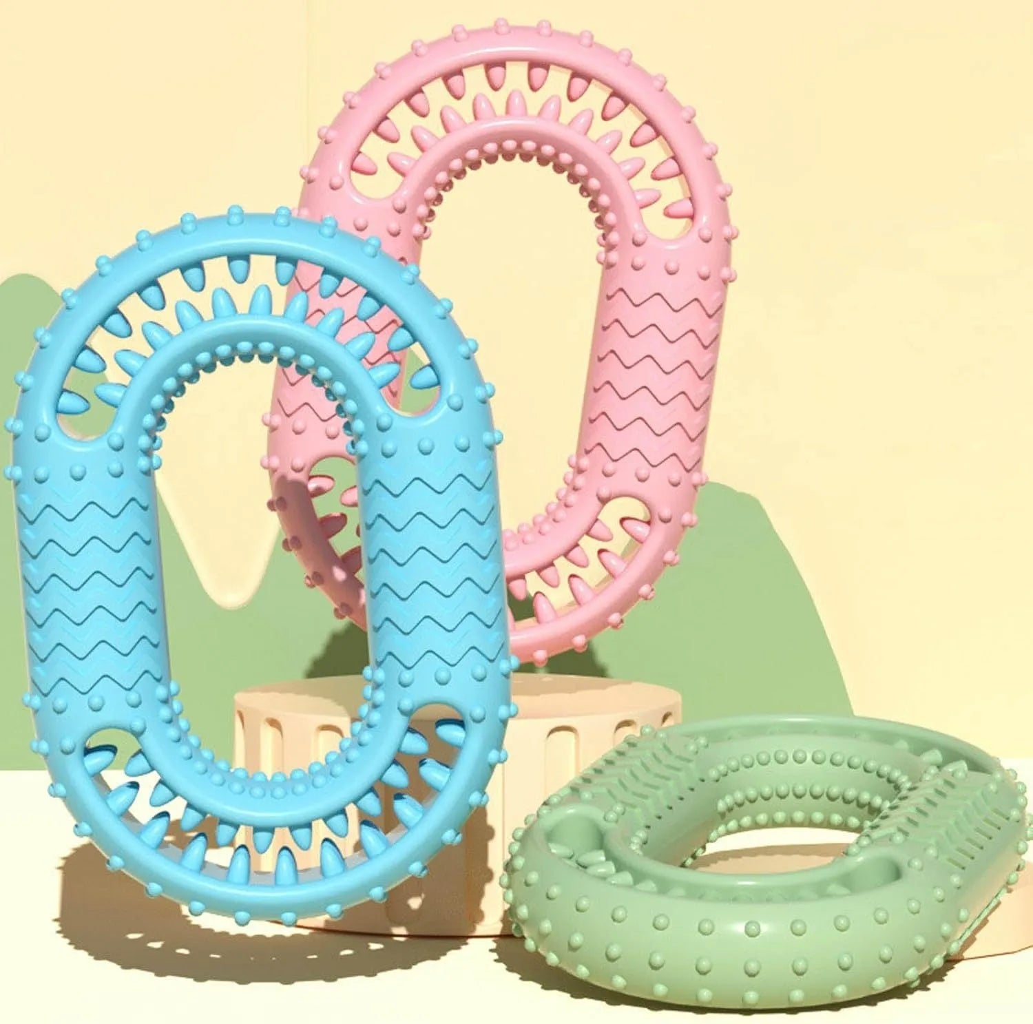 Blue, green, and pink O-ring shaped durable dog chew toy for aggressive chewers.