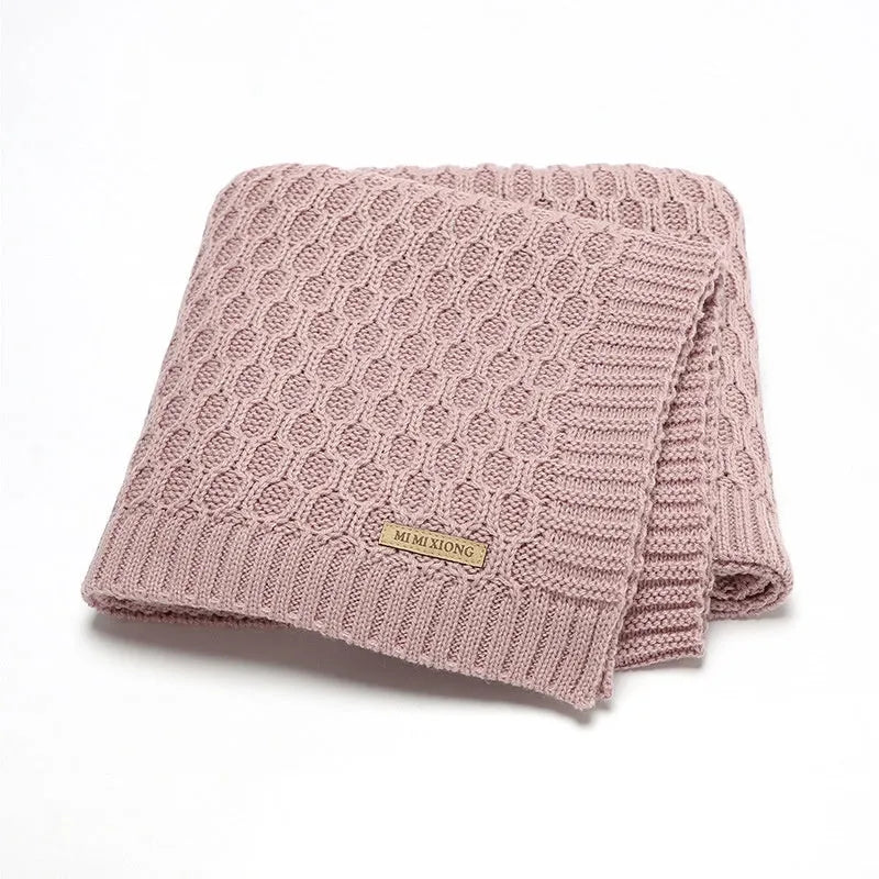 Solid colour infant hug blanket with textured lines, shown in acrylic fabric measuring 70 by 90 cm.
