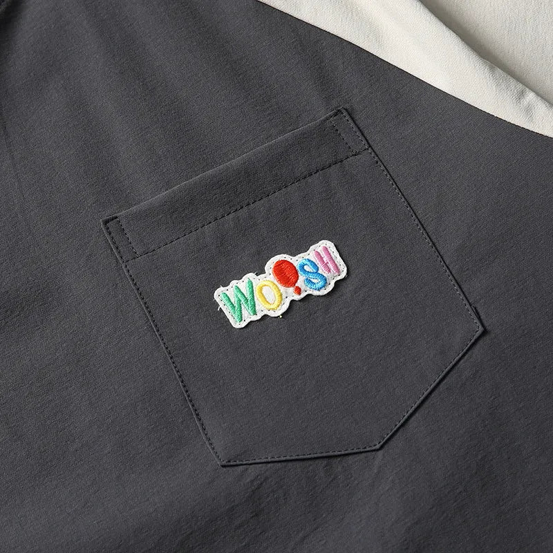 Dark grey loose-fit t-shirt with contrast colour raglan short sleeves on a hanger.