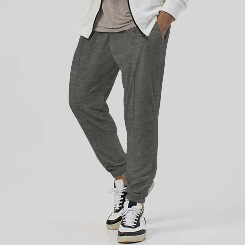 Men's loose tapered casual sweatpants in a grey cotton blend fabric with an elastic waistband.