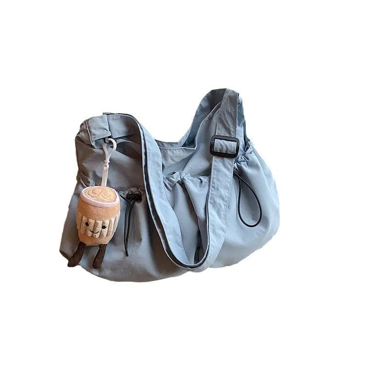 Soft green pleated foldable crossbody bag showing split pocket and internal mobile phone compartment