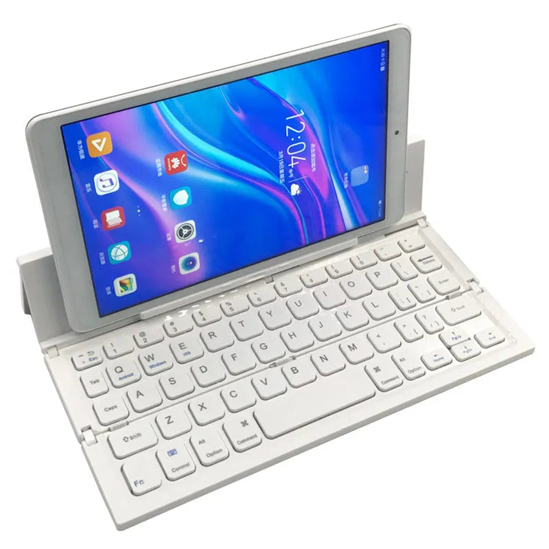 A black mini folding wireless Bluetooth keyboard shown open next to a tablet.
