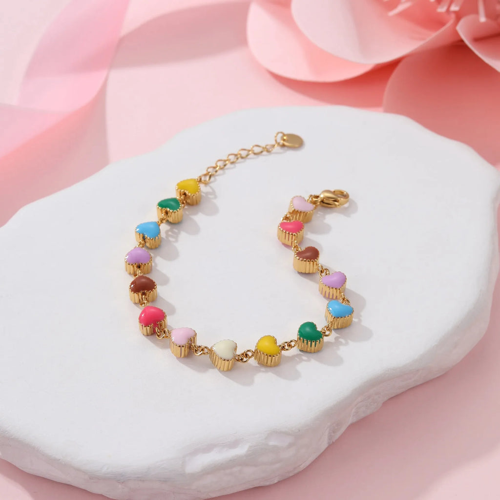 Close-up of a women's love heart-shaped bracelet in stainless steel with 18K gold plating.